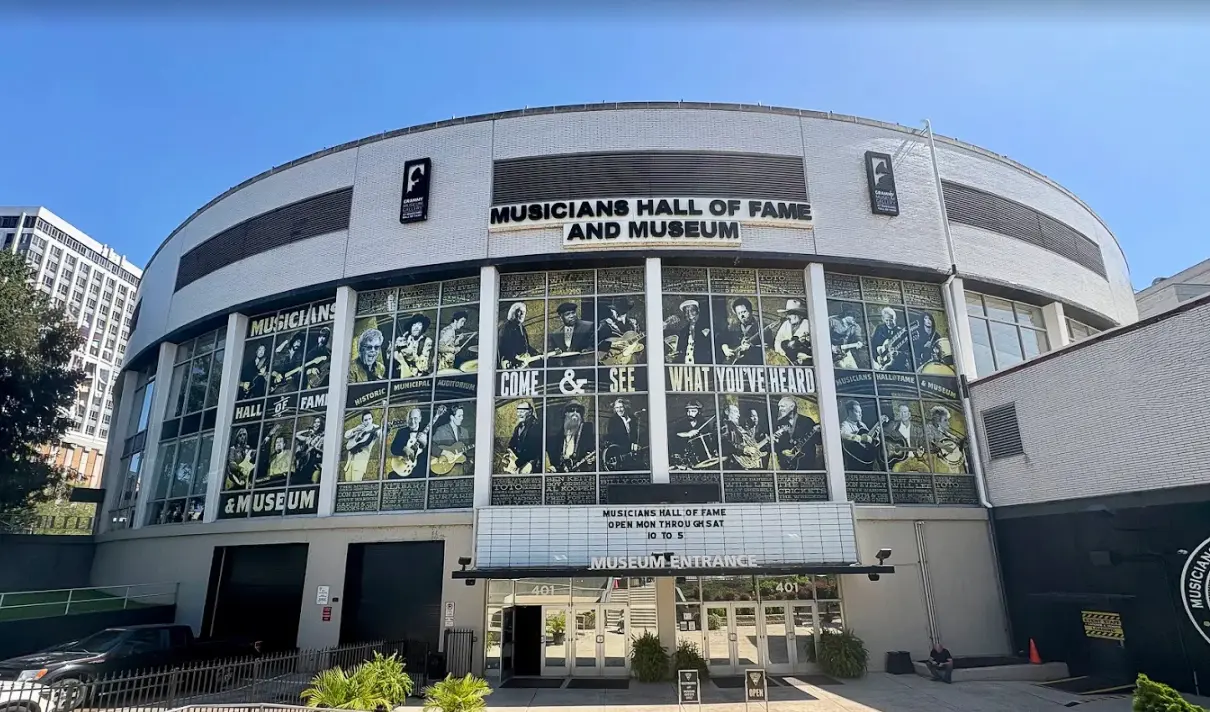 woman with a bob haircut holding a camera up to her face with a light in the background