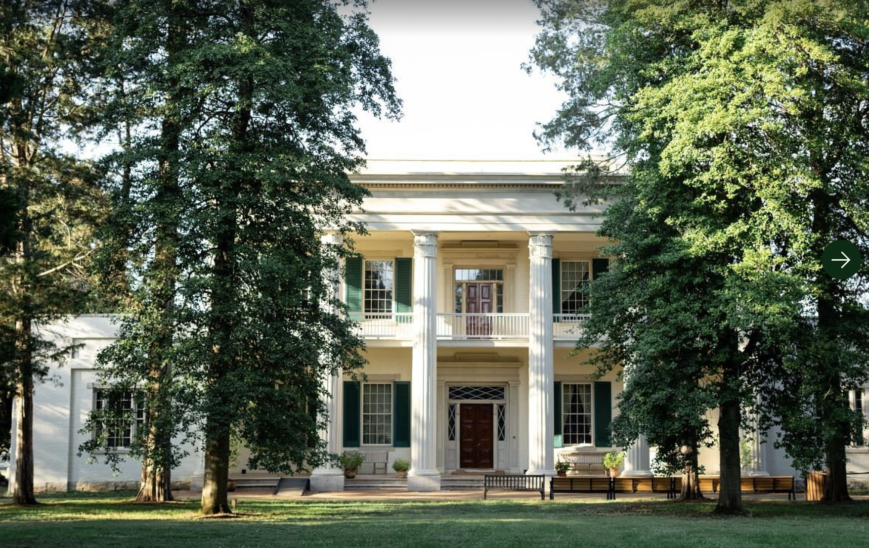 woman with a bob haircut holding a camera up to her face with a light in the background