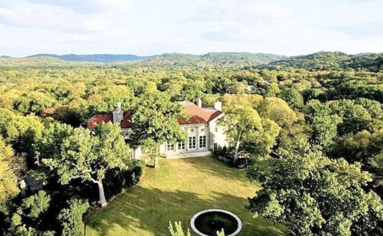 woman with a bob haircut holding a camera up to her face with a light in the background