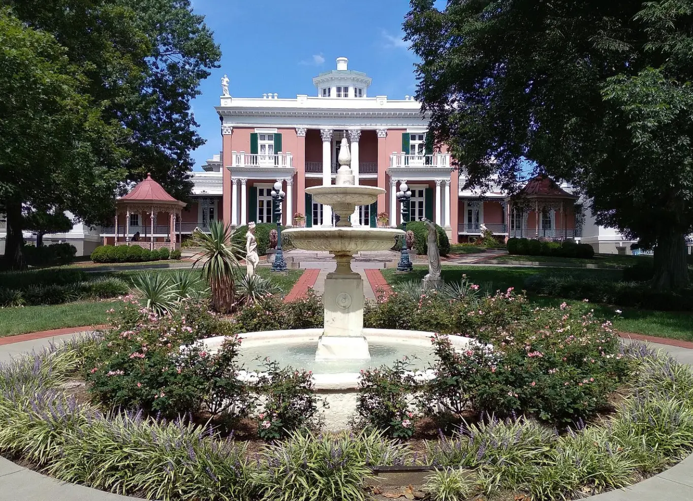 woman with a bob haircut holding a camera up to her face with a light in the background