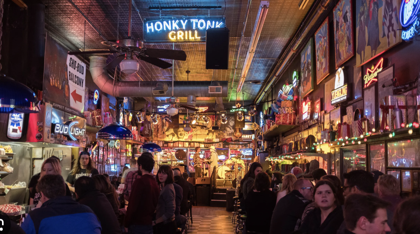 woman with a bob haircut holding a camera up to her face with a light in the background