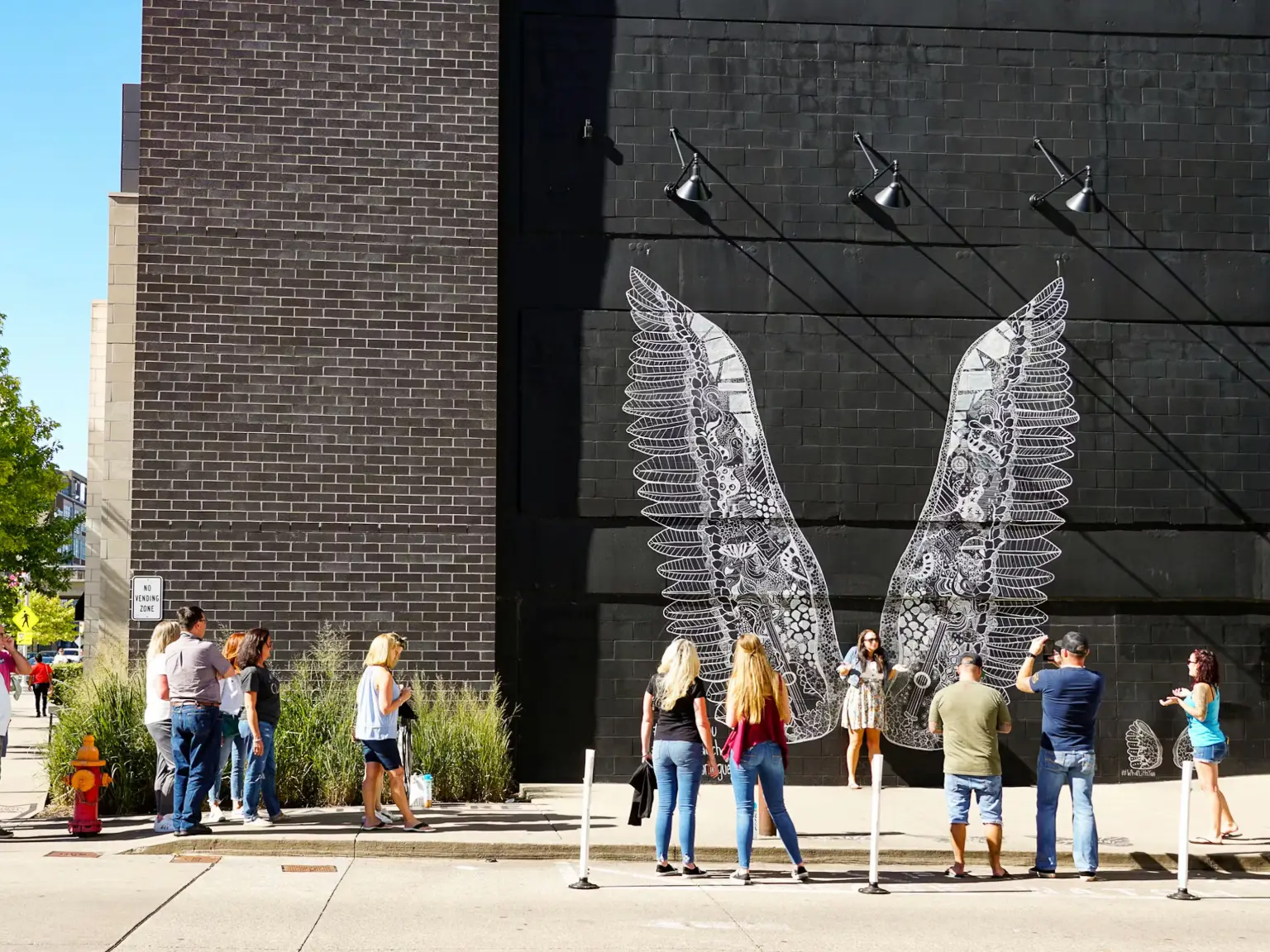woman with a bob haircut holding a camera up to her face with a light in the background