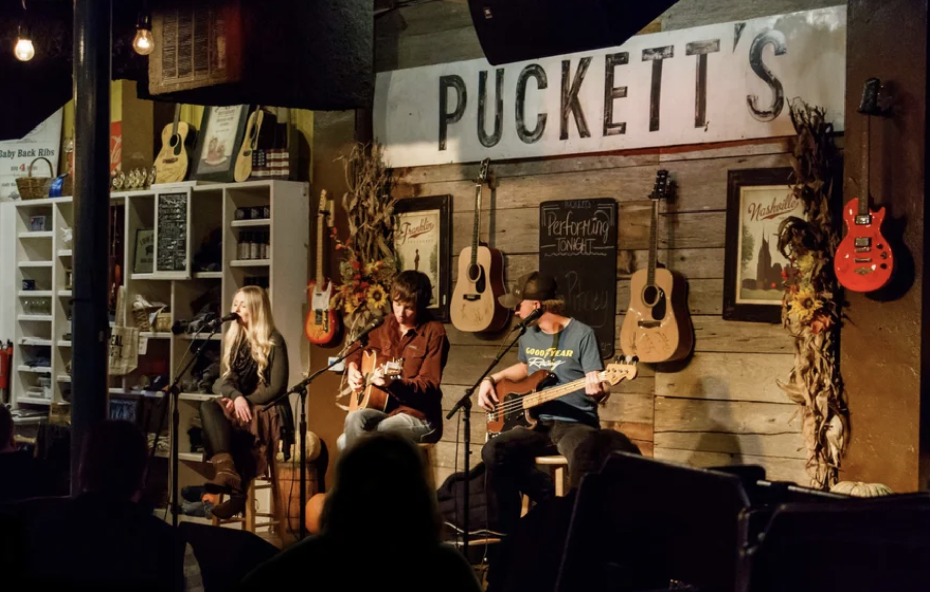 woman with a bob haircut holding a camera up to her face with a light in the background