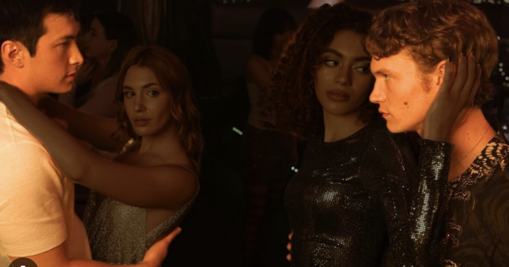 woman with a bob haircut holding a camera up to her face with a light in the background