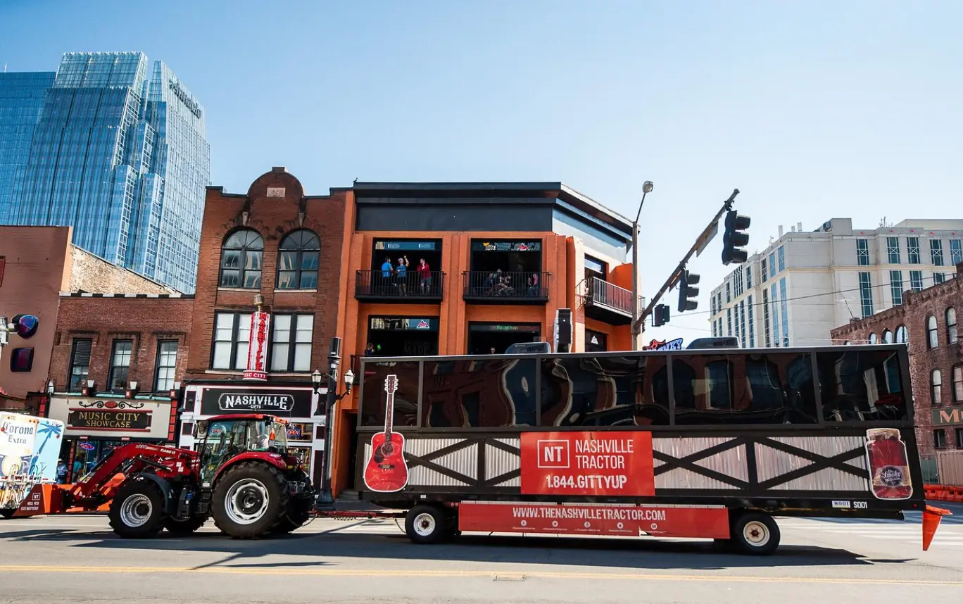 woman with a bob haircut holding a camera up to her face with a light in the background