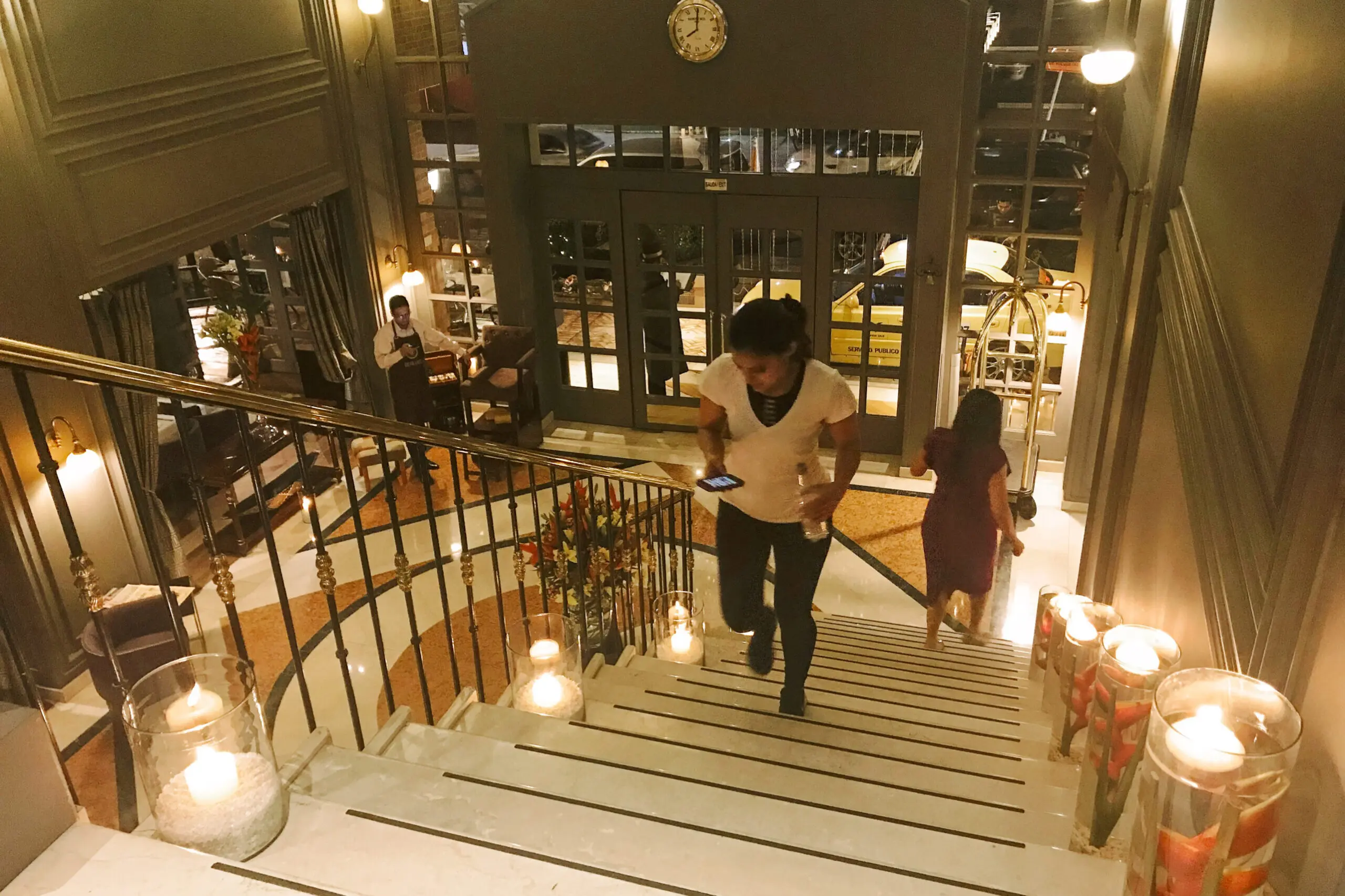 woman with a bob haircut holding a camera up to her face with a light in the background