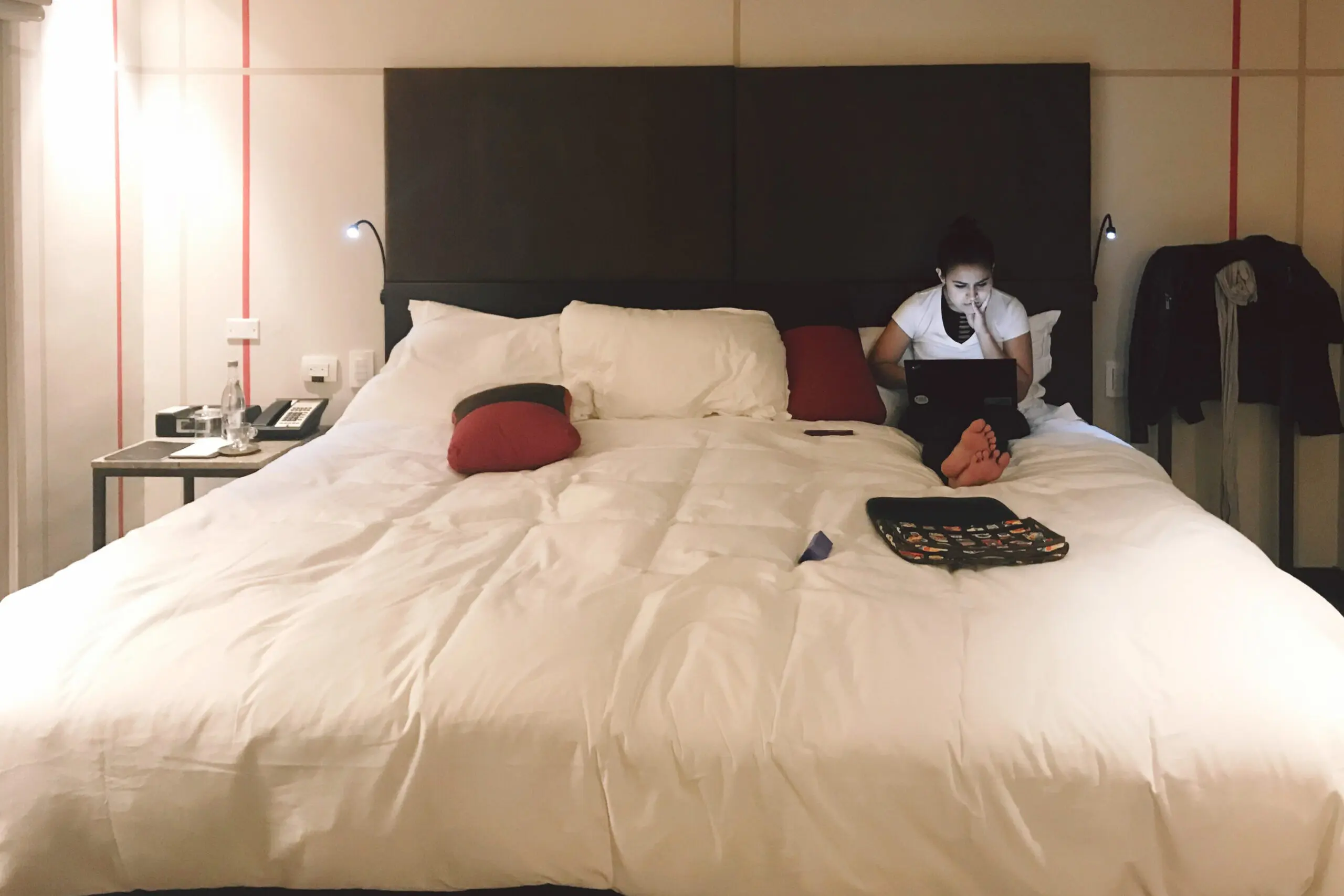 woman with a bob haircut holding a camera up to her face with a light in the background