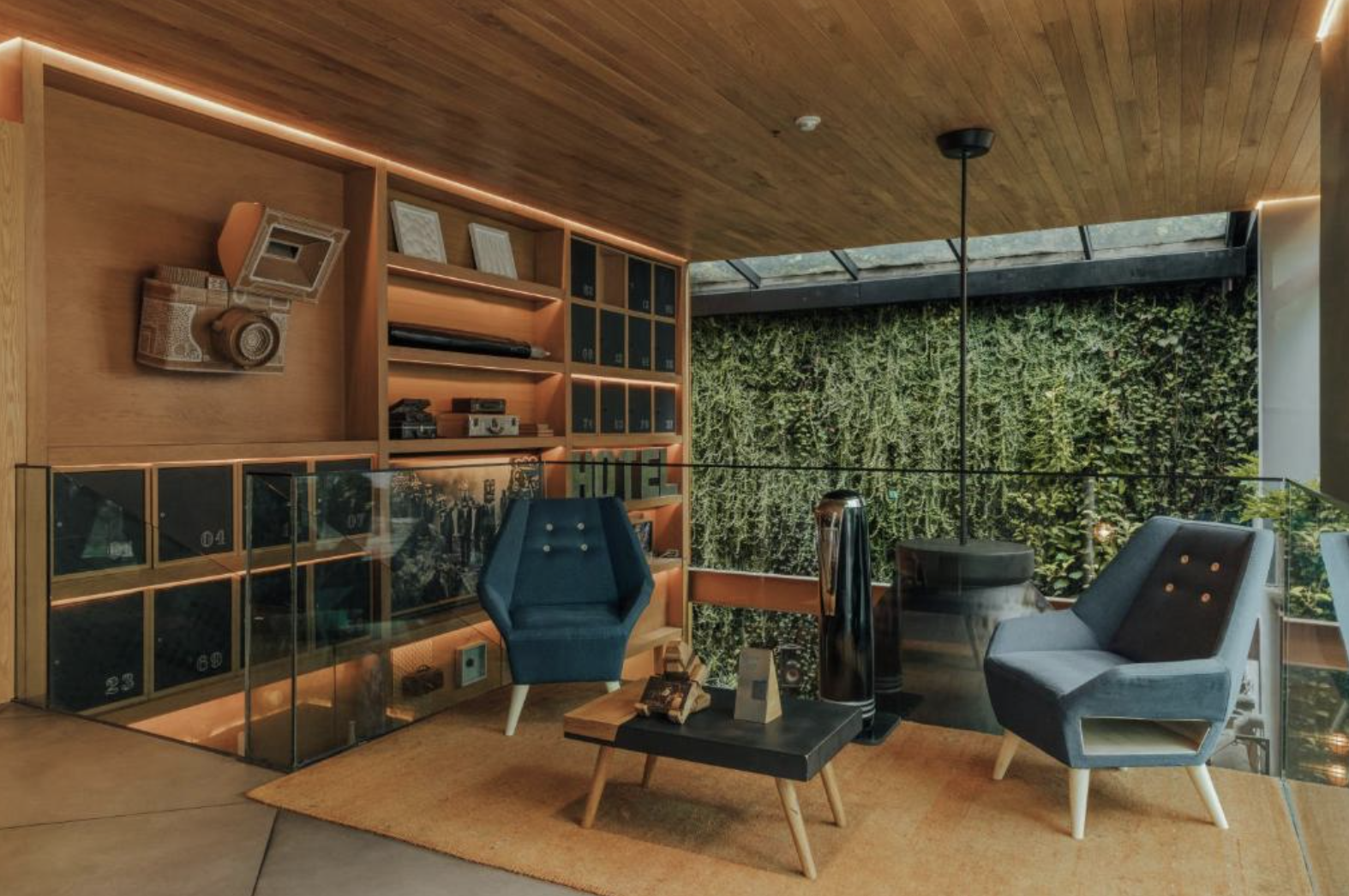 woman with a bob haircut holding a camera up to her face with a light in the background