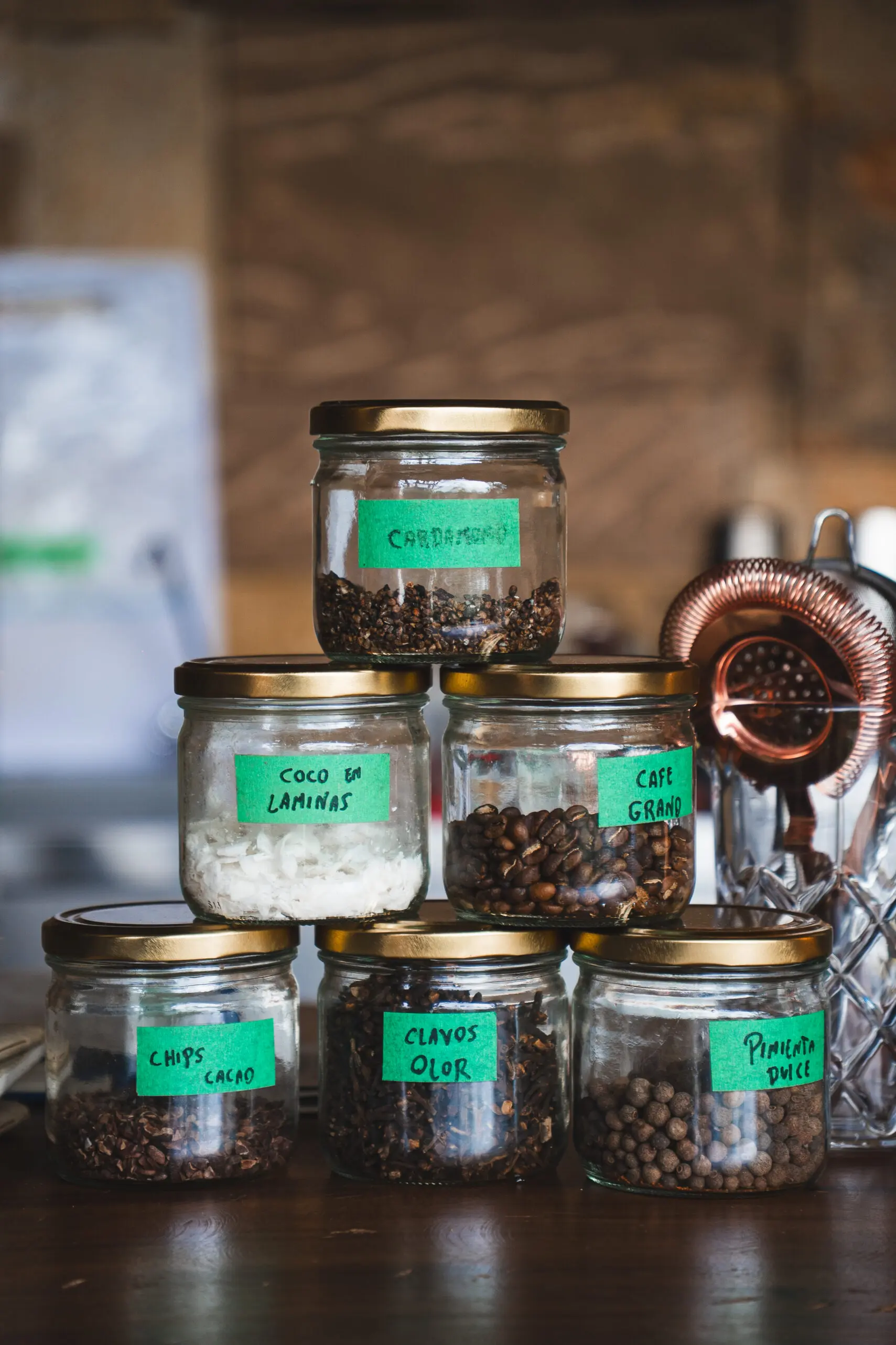 Jars labeled with various herbs and spices on a wooden surface.