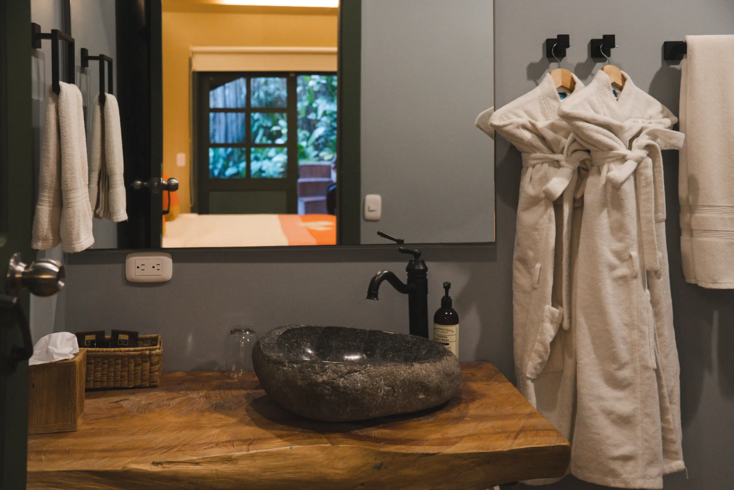 Rustic bathroom with stone sink and wooden countertop.