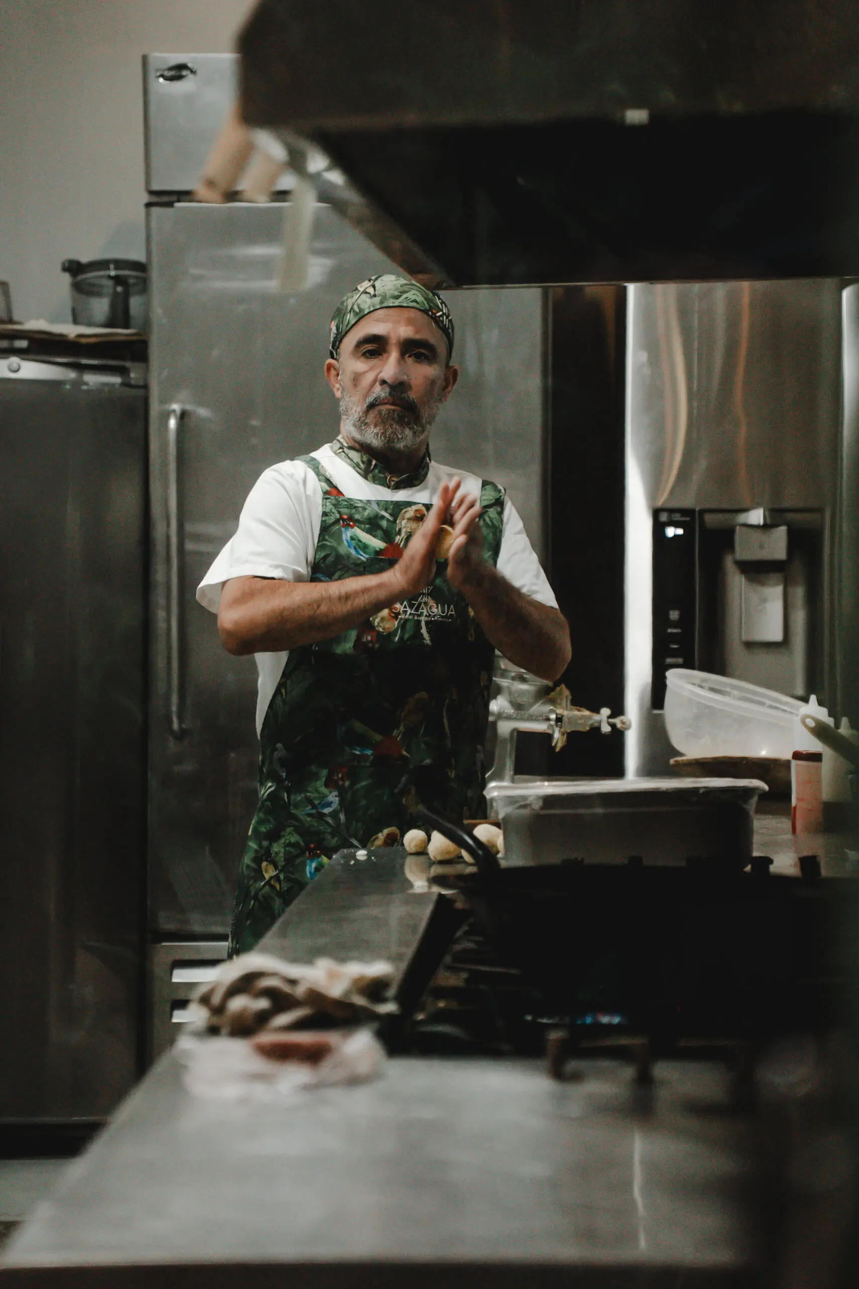 Chef in kitchen preparing food, hands in a prayer-like gesture. Chef in kitchen preparing food, hands in a prayer-like gesture.