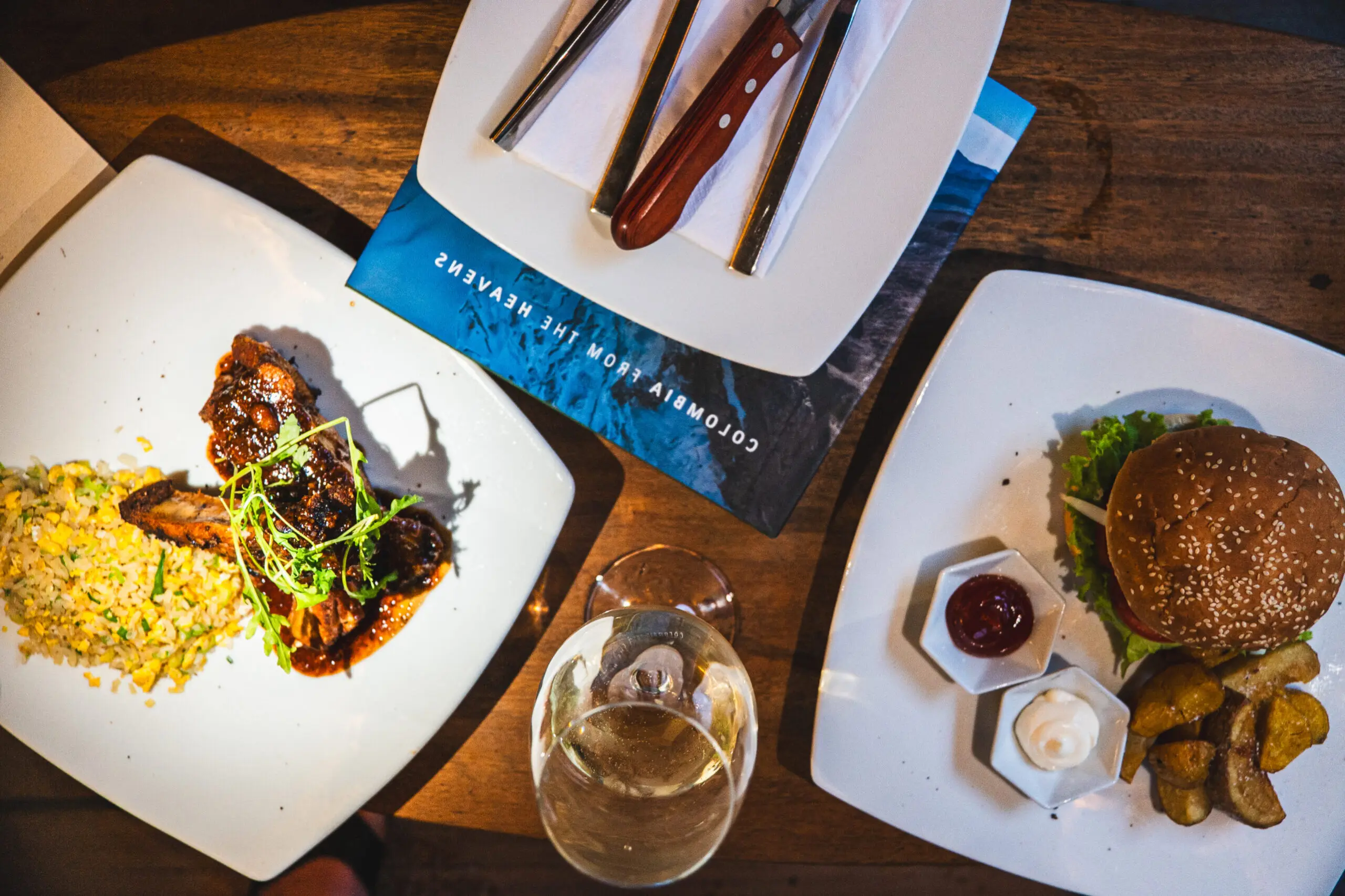 An elegant dining setup with gourmet dishes and a glass of white wine.