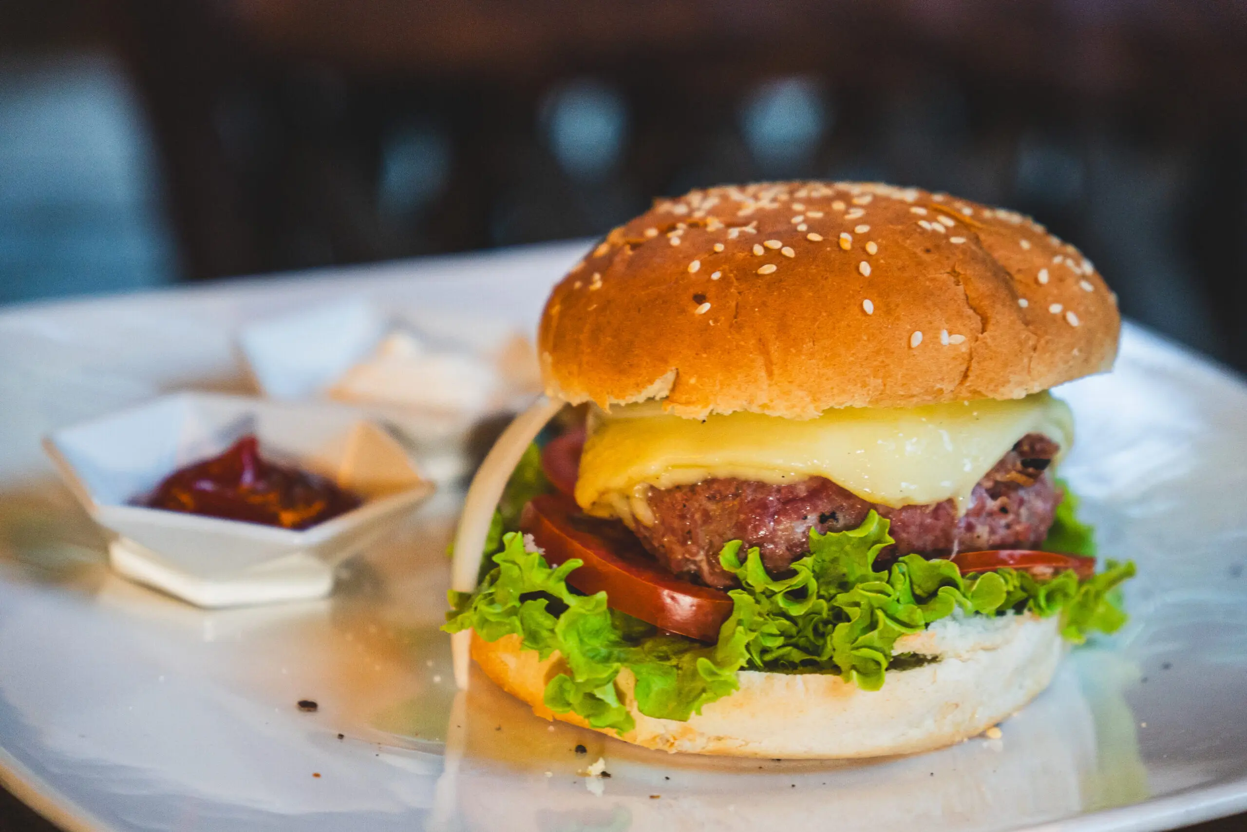 Juicy bacon cheeseburger with fresh lettuce on a sesame bun.