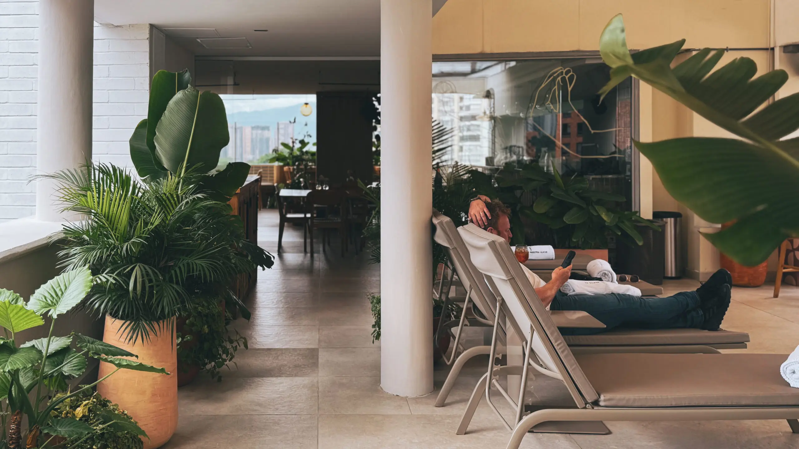 Colombia, Medellín, Hotels & Rooftops, Sites Woman laying out on a chaise lounger over. a pool in the jungle