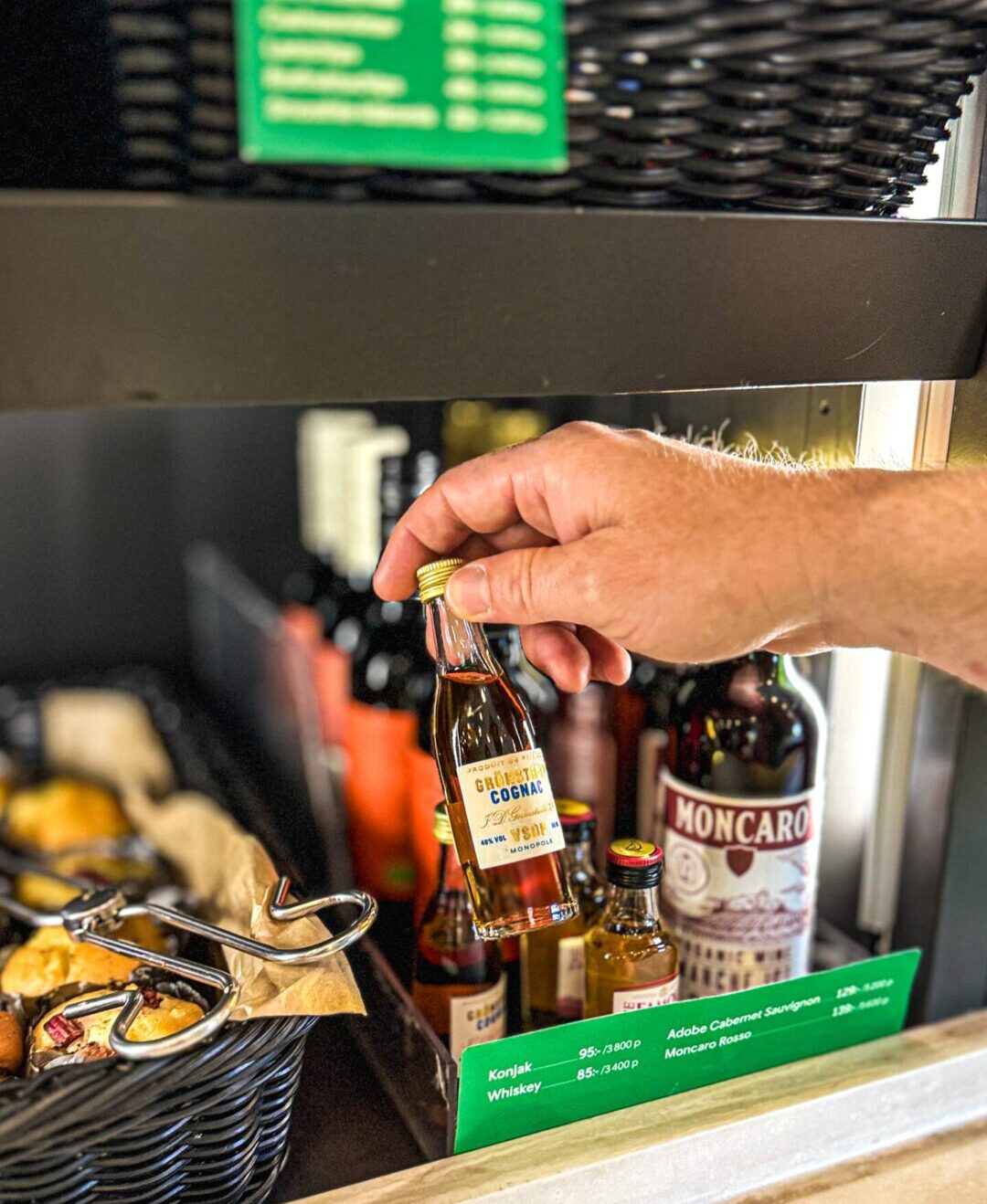 Man's hand picking up a bottle of travel wine