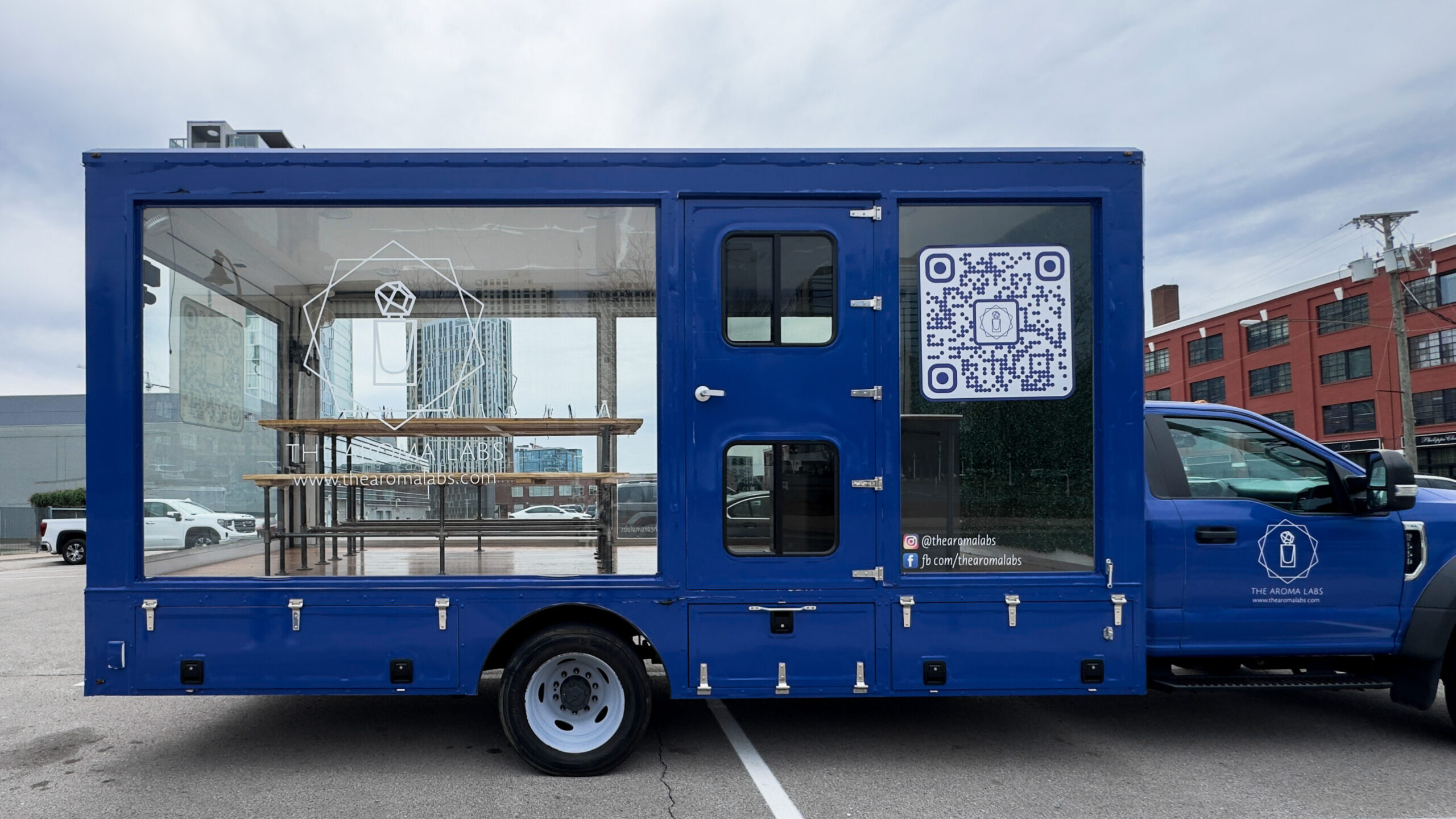 woman with a bob haircut holding a camera up to her face with a light in the background