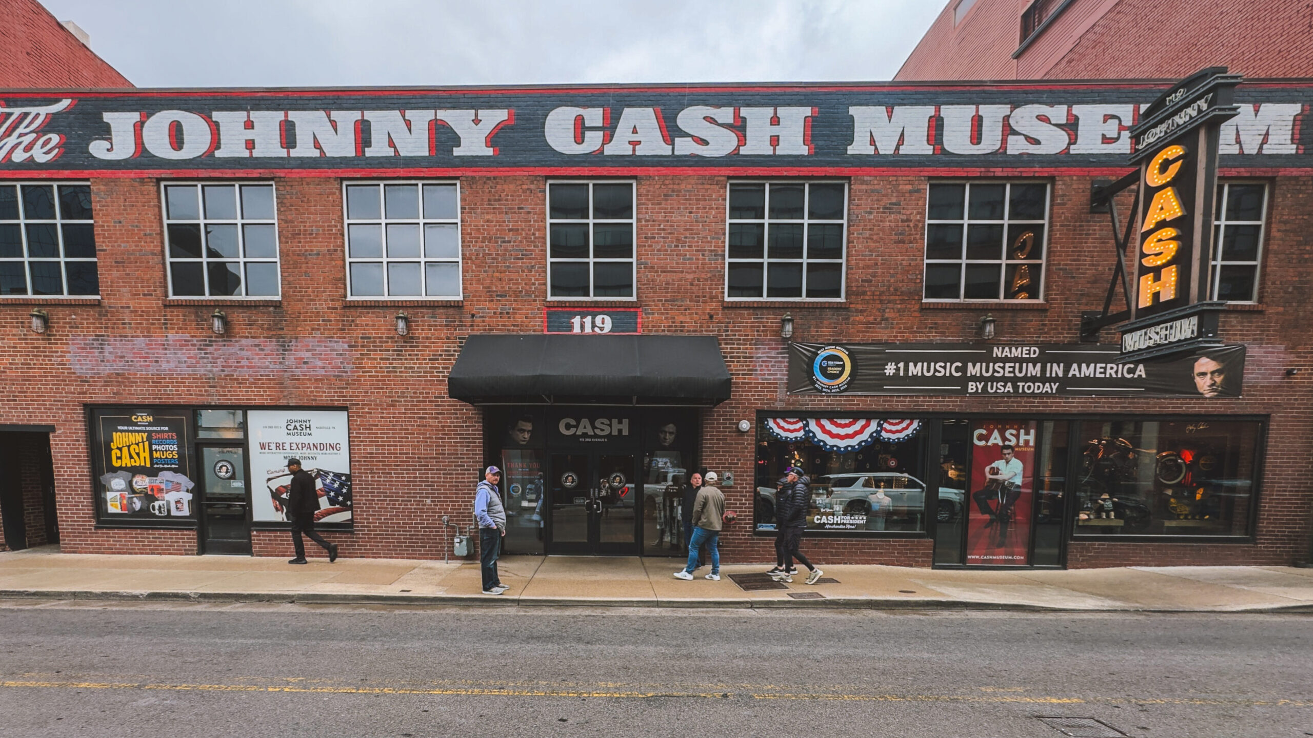 woman with a bob haircut holding a camera up to her face with a light in the background