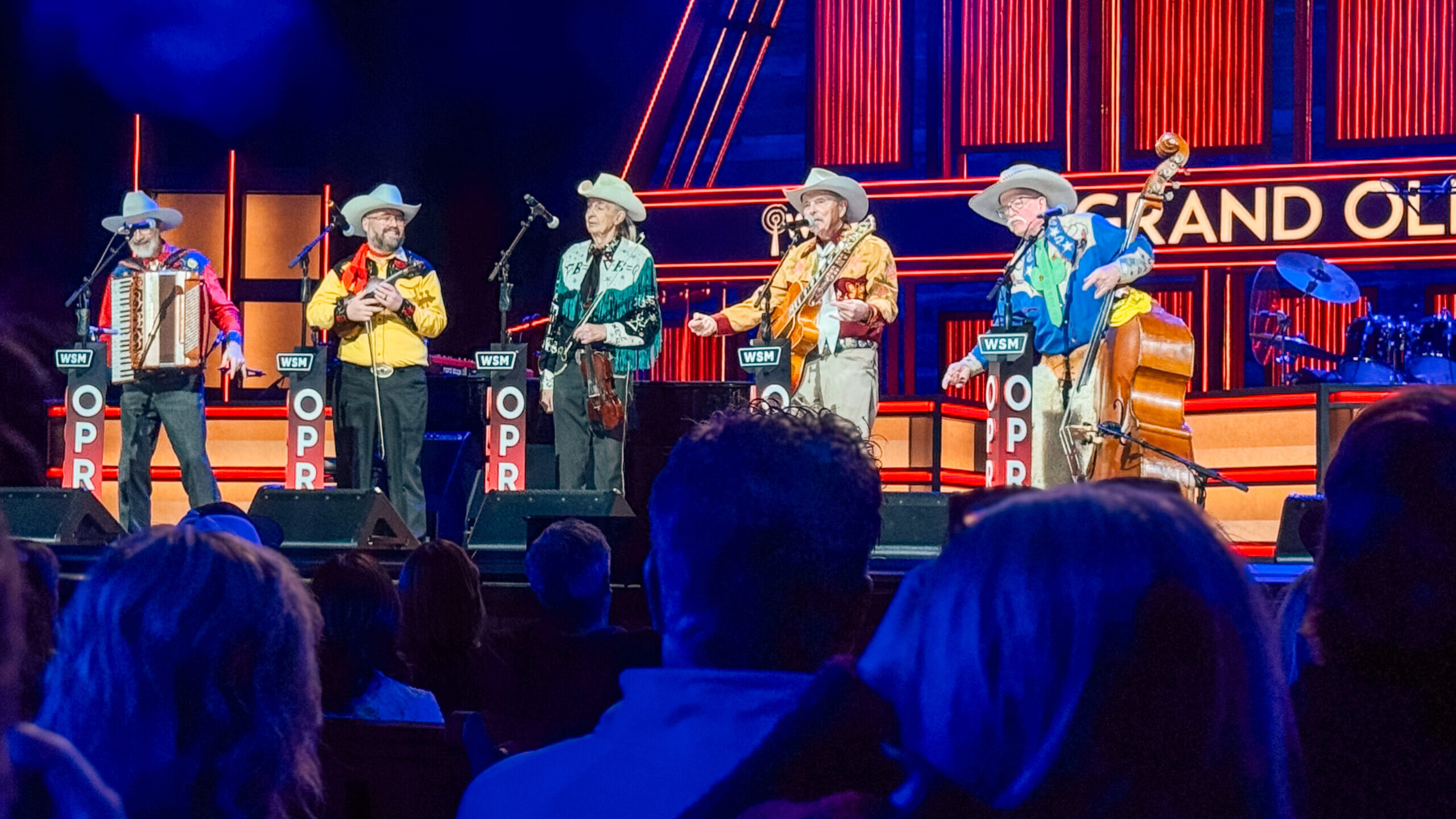 woman with a bob haircut holding a camera up to her face with a light in the background