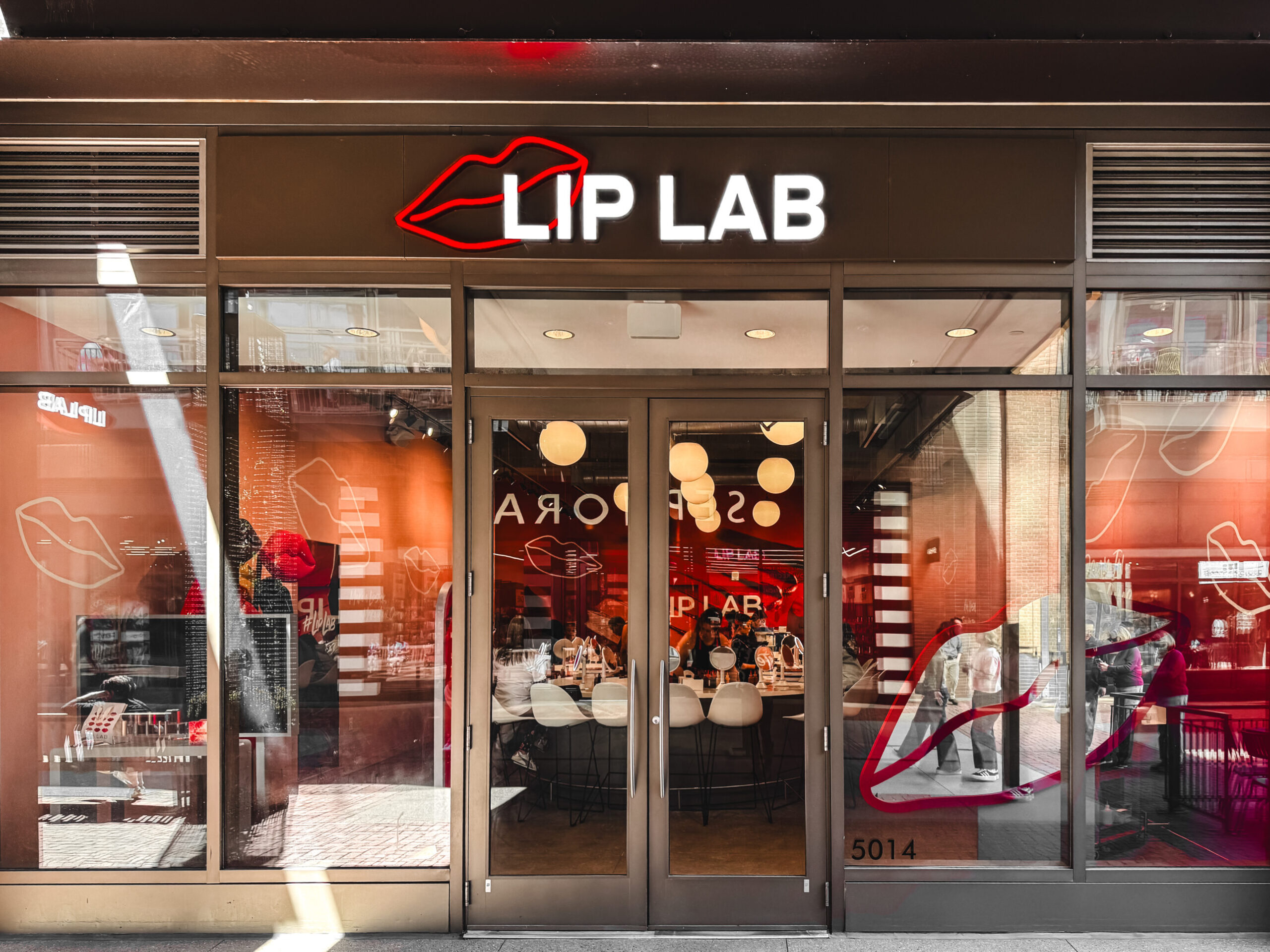 woman with a bob haircut holding a camera up to her face with a light in the background