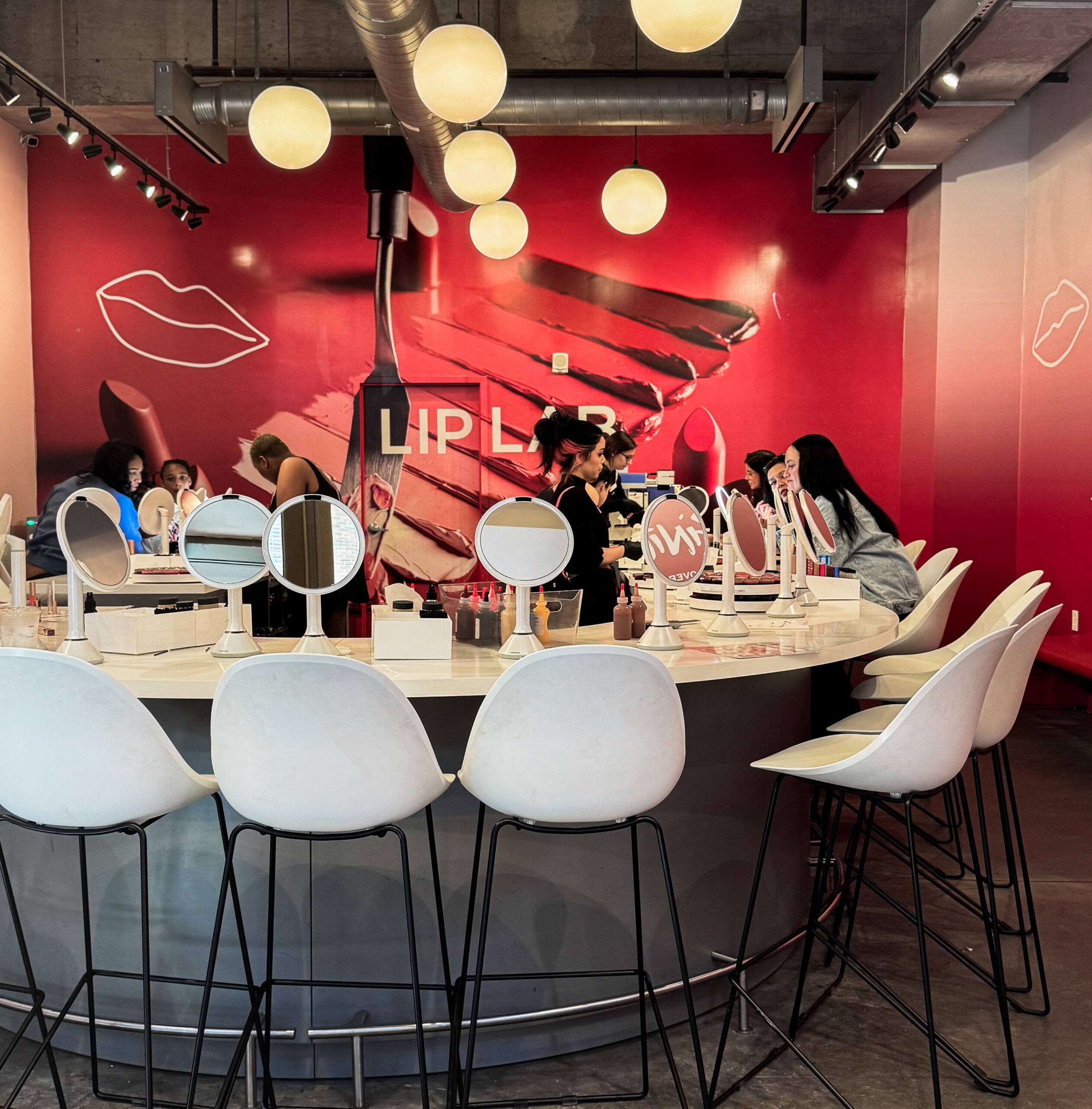 woman with a bob haircut holding a camera up to her face with a light in the background
