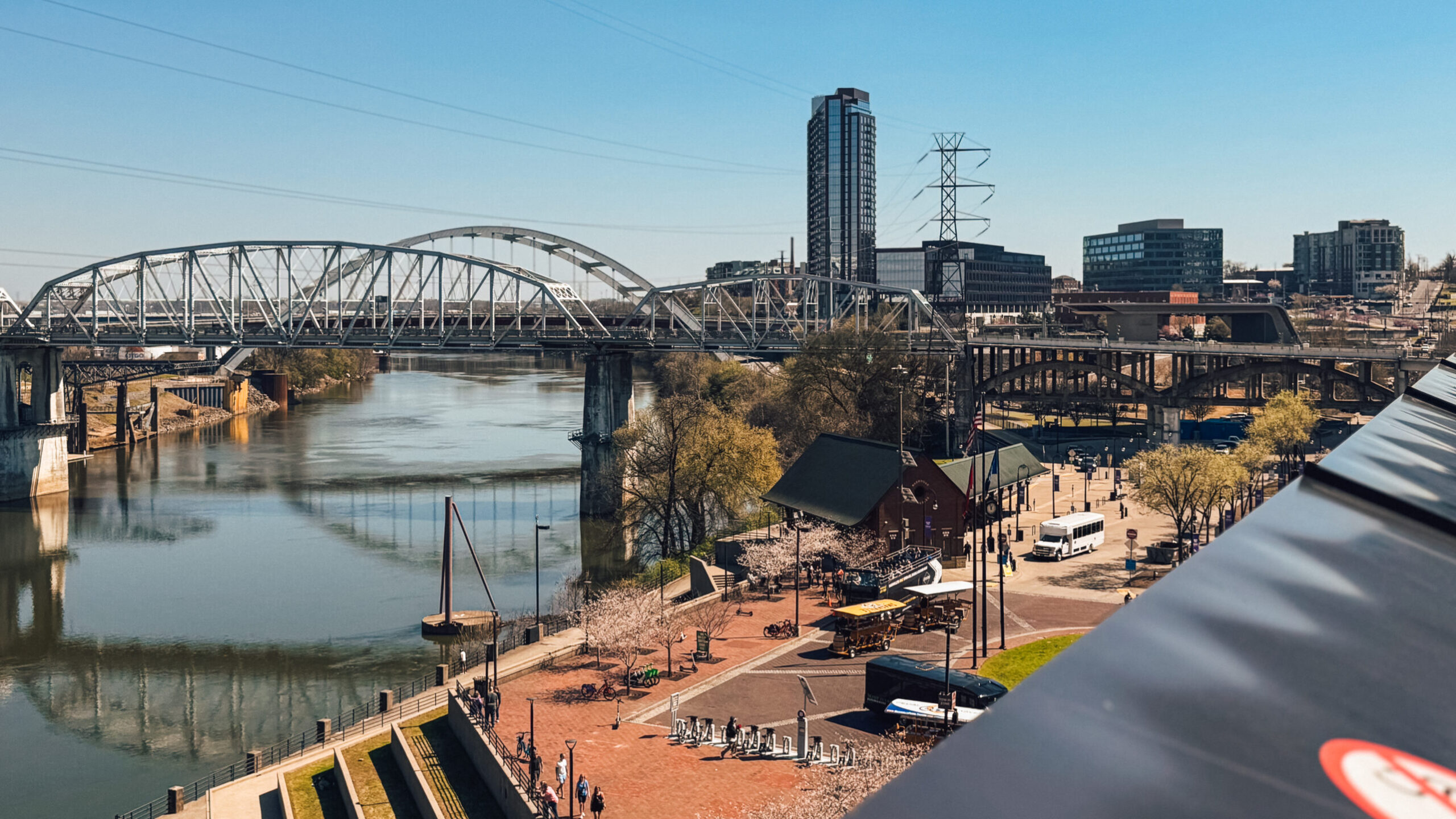 woman with a bob haircut holding a camera up to her face with a light in the background