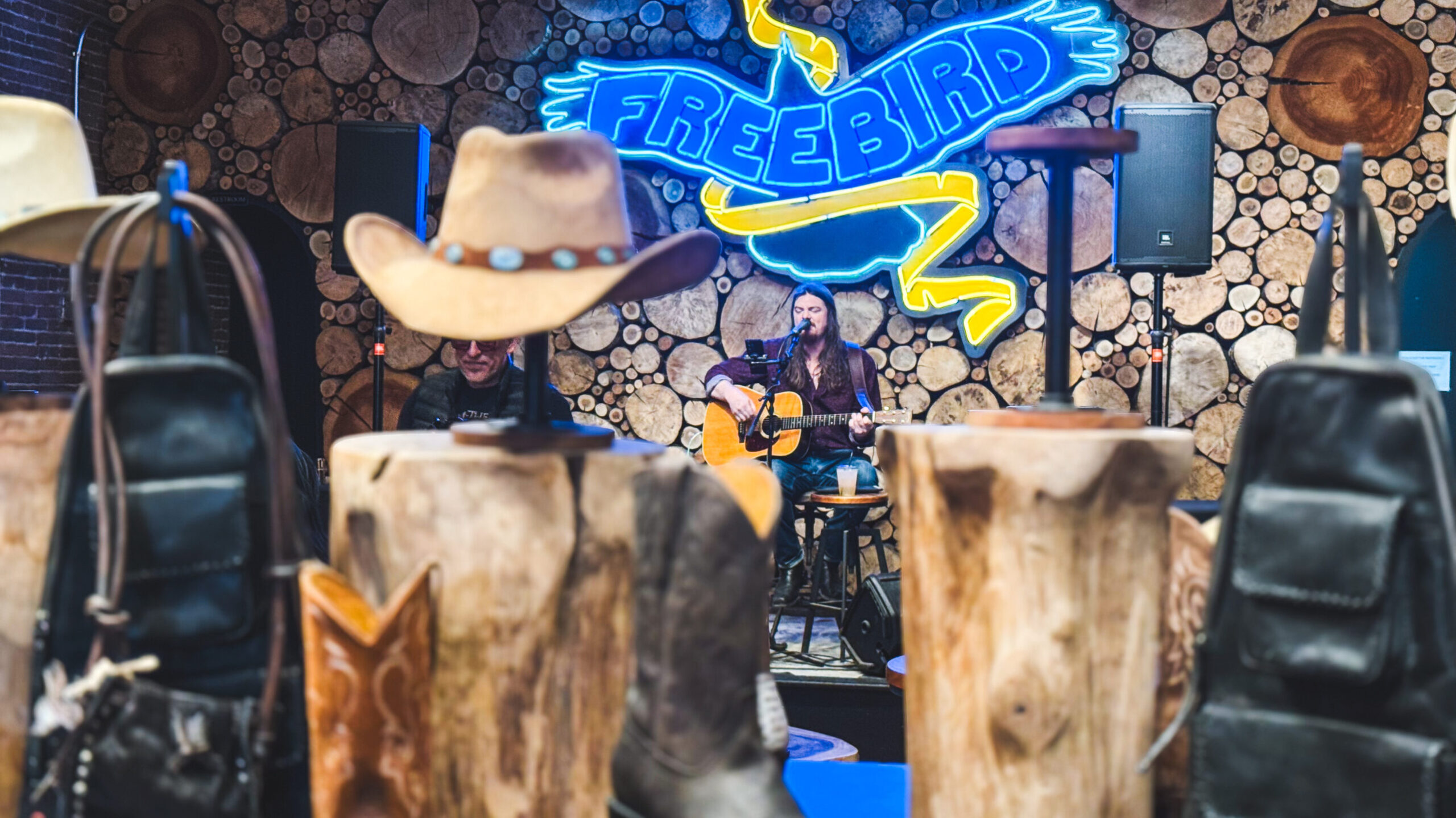 woman with a bob haircut holding a camera up to her face with a light in the background