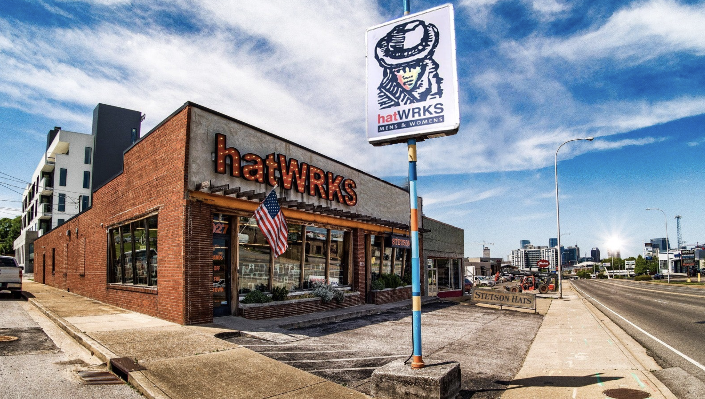 woman with a bob haircut holding a camera up to her face with a light in the background