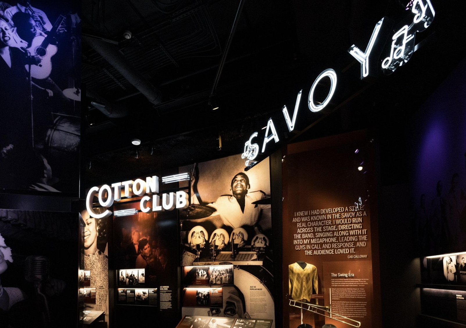 woman with a bob haircut holding a camera up to her face with a light in the background