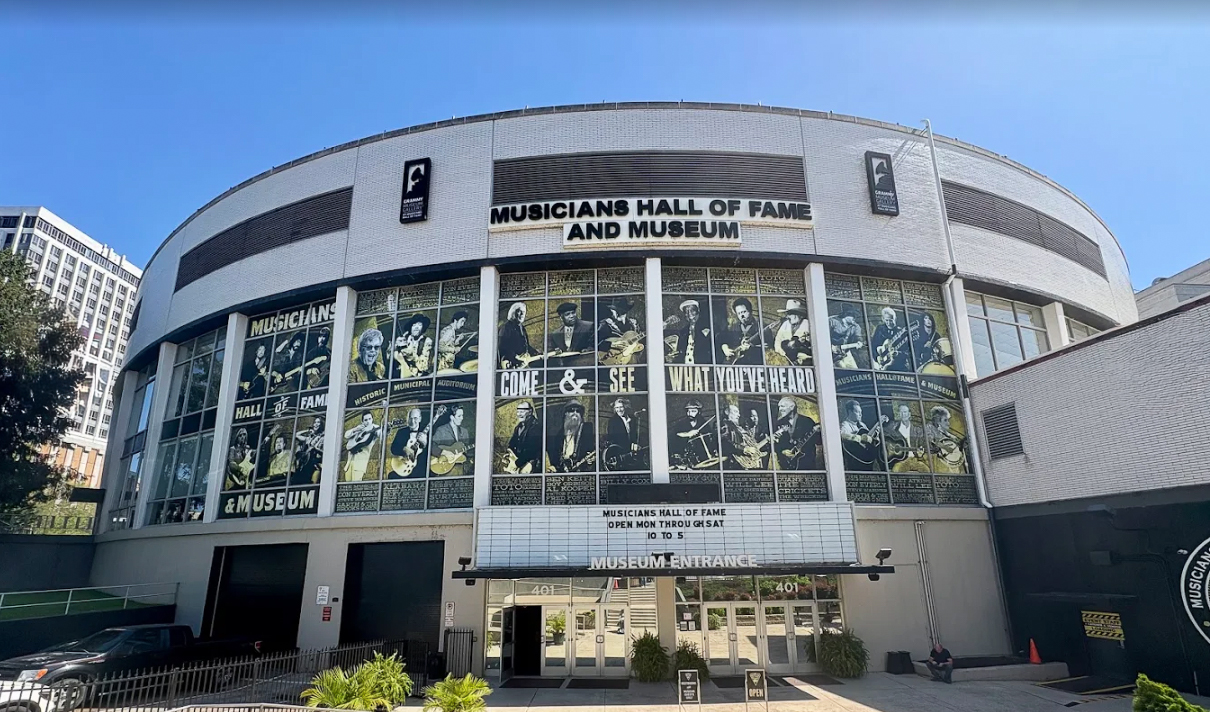 woman with a bob haircut holding a camera up to her face with a light in the background