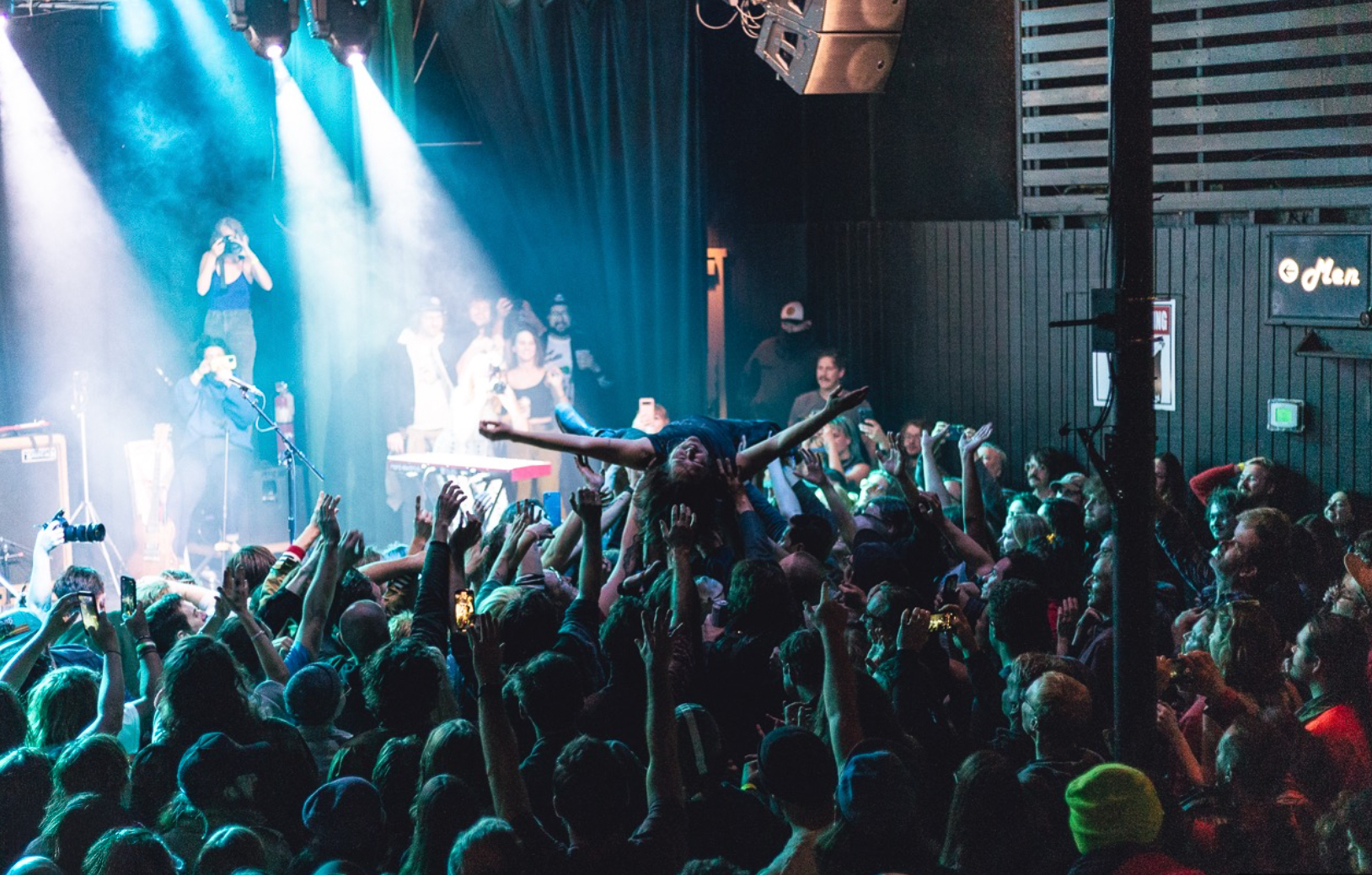 woman with a bob haircut holding a camera up to her face with a light in the background