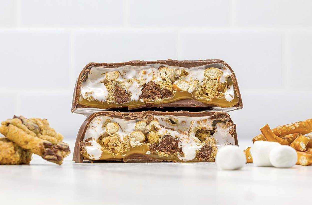 woman with a bob haircut holding a camera up to her face with a light in the background