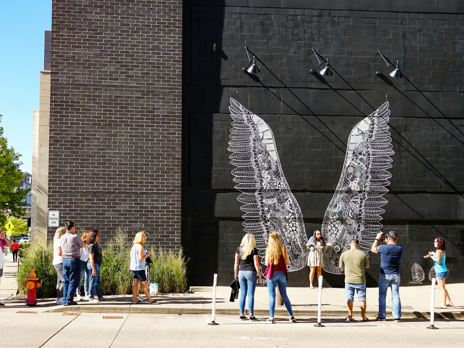 woman with a bob haircut holding a camera up to her face with a light in the background
