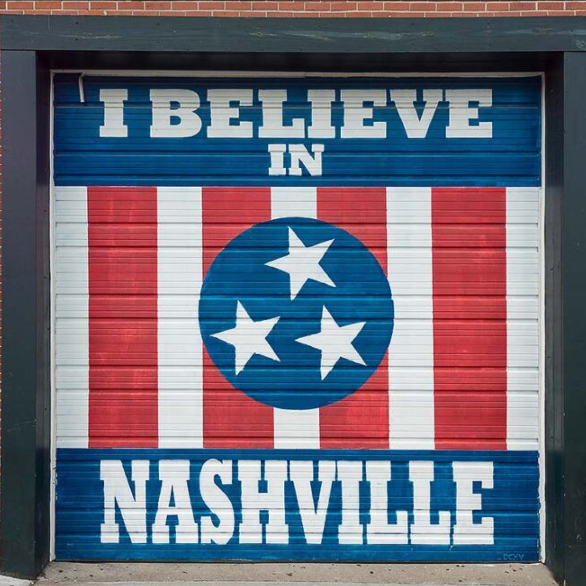 woman with a bob haircut holding a camera up to her face with a light in the background