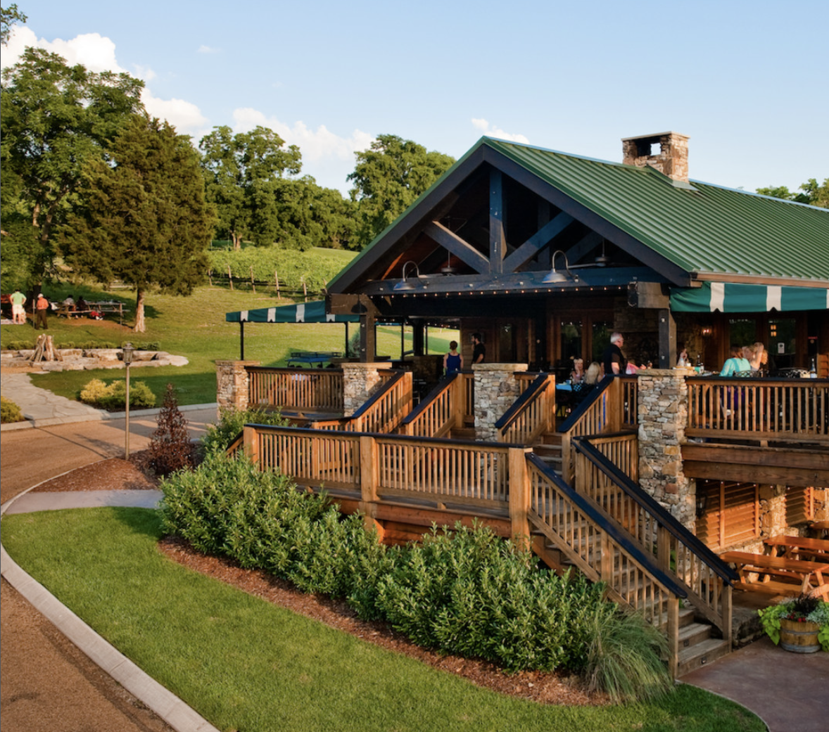 woman with a bob haircut holding a camera up to her face with a light in the background
